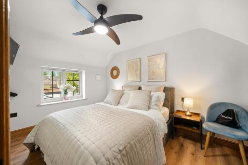 a bedroom with a bed and a ceiling fan at Blacksmiths Cottage by Birch Stays in Needwood