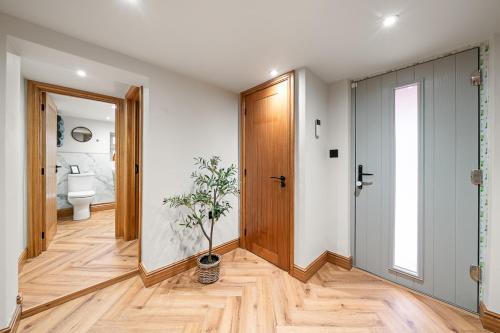 a hallway with a door and a potted plant at Blacksmiths Cottage by Birch Stays in Needwood