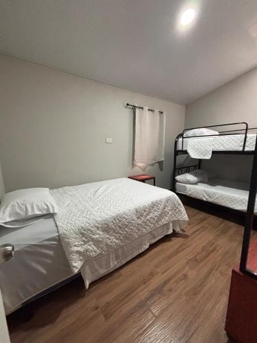 a bedroom with two bunk beds and a wooden floor at Quinta Los 3 Tesoros in San Francisco Amatepe