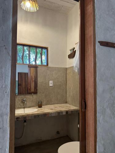 a bathroom with a sink and a mirror at Odoyá Corumbau in Corumbau