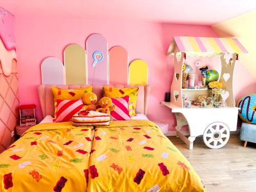 a bedroom with a yellow bed with a pink wall at Candypartment Sweets 'n Sleep in Gelsenkirchen