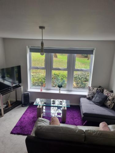 a living room with a couch and a large window at The Pringle Inn in Great Baddow