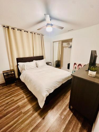 a bedroom with a bed and a ceiling fan at Stunning Oasis with Pool by Disneyland and Knotts in Buena Park