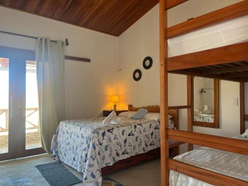 a bedroom with two bunk beds and a window at Pousada Paracuru Surf in Paracuru