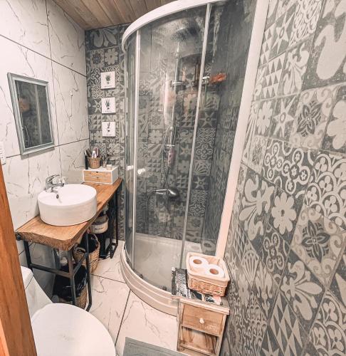 a bathroom with a shower and a sink at Cabaña de Montaña con Río in Puhala