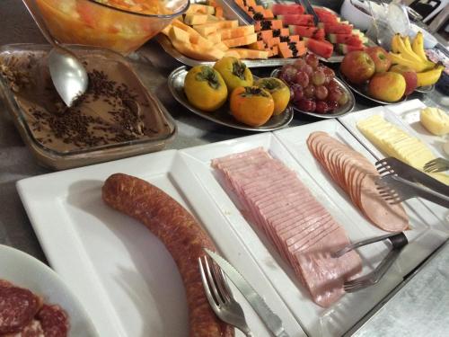 een tafel vol voedsel met vlees en andere voedingsmiddelen bij Estrela Palace Hotel in Estrêla
