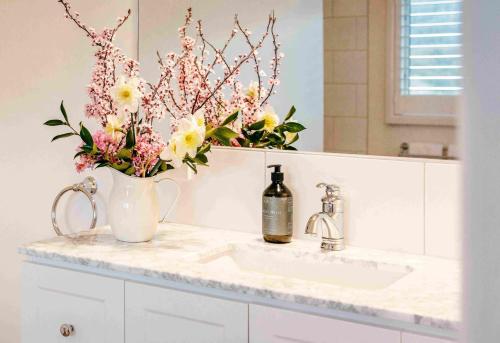 a bathroom sink with a vase of flowers on it at Scenic Marysville in Marysville