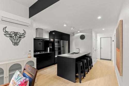 a kitchen with black and white counters and a counter top at Shotover View - Family friendly close to Coronet Peak in Frankton Wharf