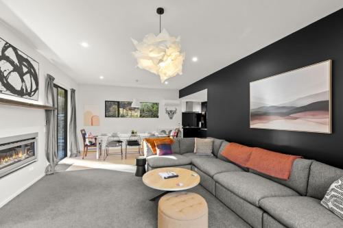 a living room with a couch and a fireplace at Shotover View - Family friendly close to Coronet Peak in Frankton Wharf