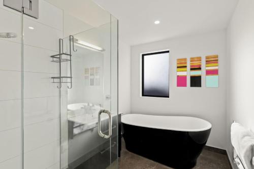 a bathroom with a bath tub and a sink at Shotover View - Family friendly close to Coronet Peak in Frankton Wharf