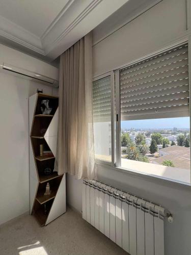 a room with a window with blinds and a radiator at Appartement central et spacieux in Monastir