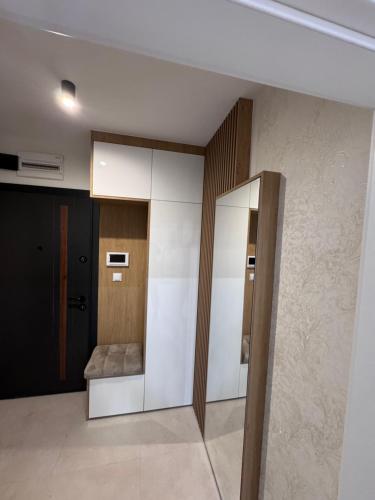 a room with a hallway with a couch and a mirror at Apartman Jaćimović in Doboj
