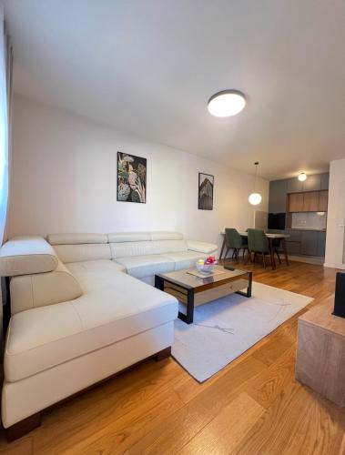 a living room with a white couch and a table at White Homes 1BR - Central Point in Podgorica