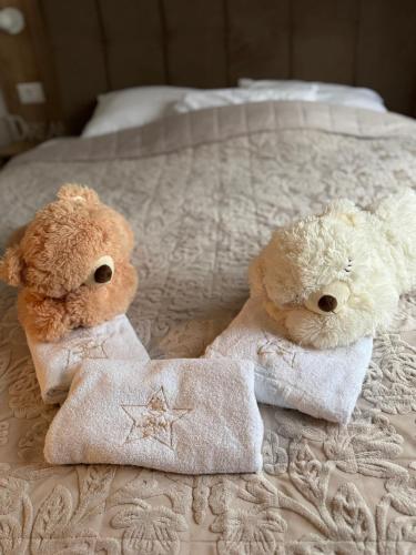 two teddy bears sitting on a bed with towels at Royal apartman Zlatibor in Palisat
