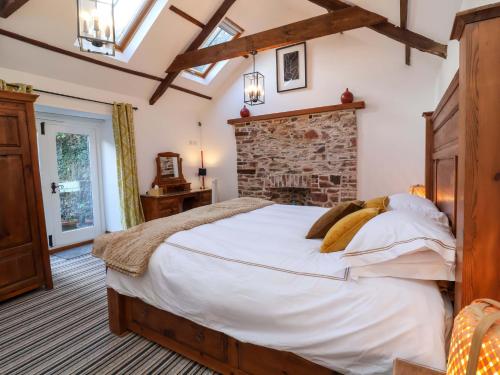a bedroom with a large bed and a brick wall at Baywatch St David's View in Lynton