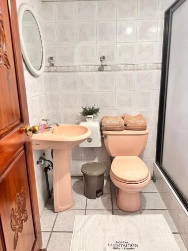 a bathroom with a pink toilet and a sink at Hostal La Estación Quito in Quito