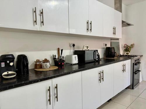 a kitchen with white cabinets and a black counter top at The Quite Resort in Birmingham