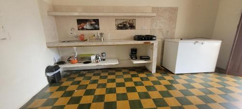 a kitchen with a refrigerator and a checkered floor at La Ermita apto in Roldanillo