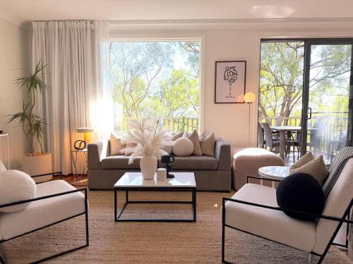 a living room with a couch and chairs and a table at Villa Croissant 2br located within Cypress Lakes Resort in Pokolbin