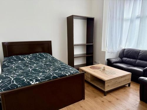 a bedroom with a bed and a couch and a table at The Quite Resort in Birmingham