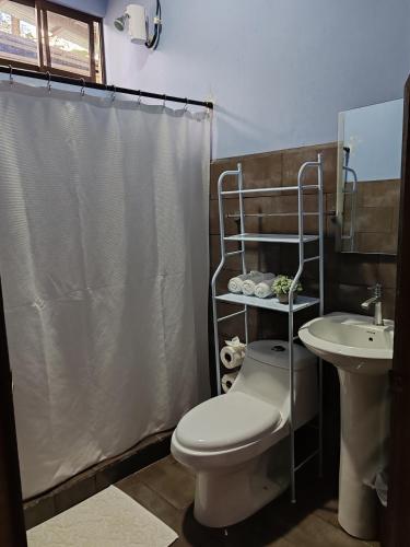 a bathroom with a toilet and a sink at Casa Hortensia in Nicoya