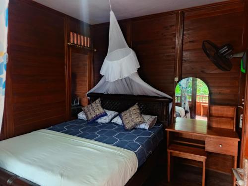 a bedroom with a bed and a desk and a bed sidx sidx sidx at Heiner Beach Homestay in Bunaken