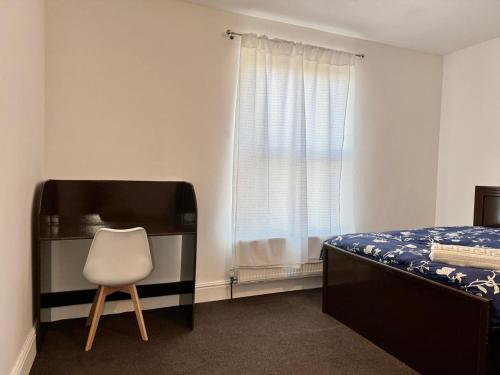 a bedroom with a bed and a chair next to a window at The Quite Resort in Birmingham