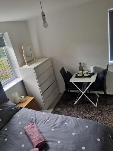 a bedroom with a bed and a table with chairs at The Pringle Inn in Great Baddow