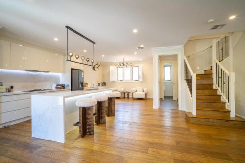 a kitchen with a counter and stools in a room at Hampton Luxe Designer Retreat with Park Views in Melbourne