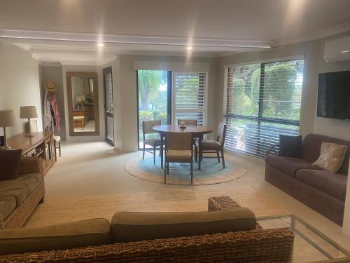 a living room with a couch and a table at The Lakeside Garden in Forster
