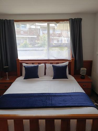 a bedroom with a large bed with a window at Cumberland Motel in Dunedin