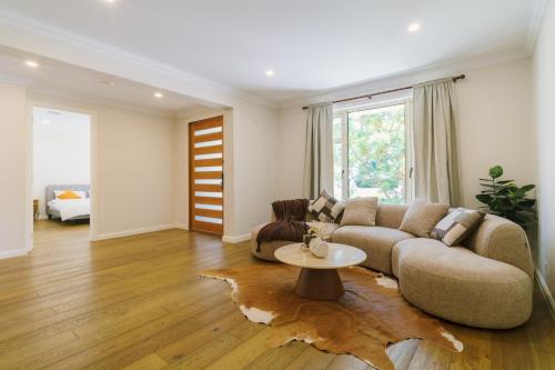 a living room with a couch and a table at Hampton Luxe Designer Retreat with Park Views in Melbourne