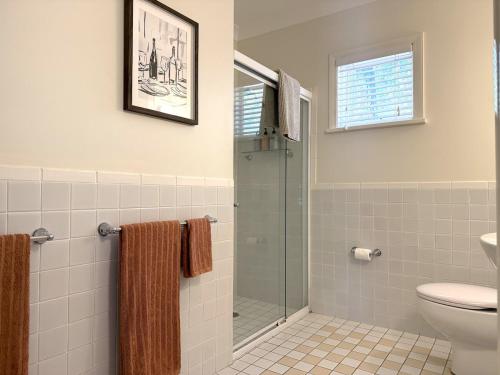a bathroom with a toilet and a glass shower at Villa Croissant 2br located within Cypress Lakes Resort in Pokolbin