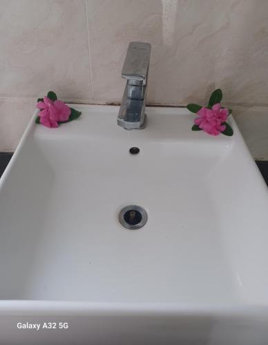 a white sink with two flowers on top of it at Nadi Fancy Hotel in Nadi