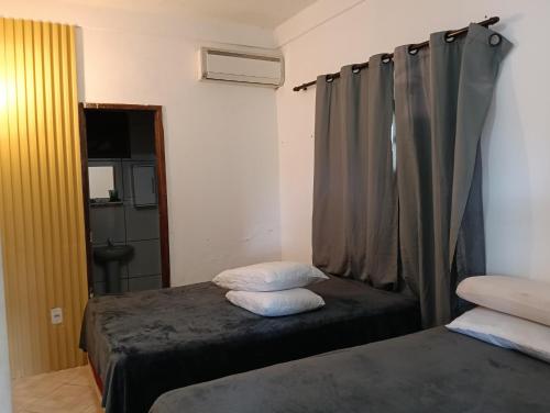 a small bedroom with two beds and a window at Sítio Moriá in Camaçari