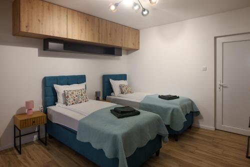 a bedroom with two beds and a cabinet at Lazar Apartman in Čantavir