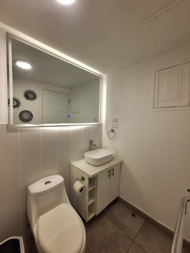 a bathroom with a toilet and a sink and a mirror at Flamingo zona 4 in Guatemala