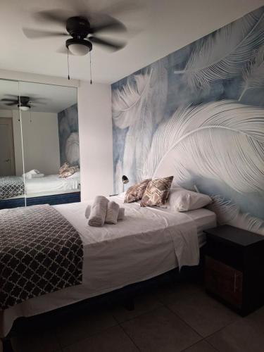a bedroom with a bed with a large painting on the wall at Flamingo zona 4 in Guatemala