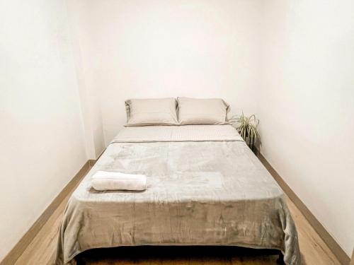 a bed in a room with white walls at Vive Medellin apartamento in Envigado