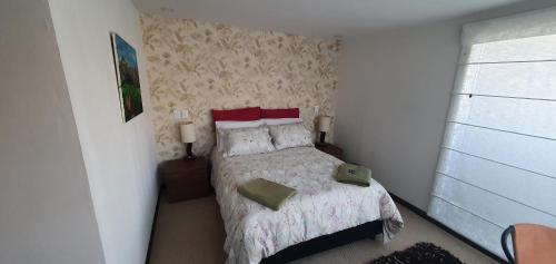 a small bedroom with a bed and a window at Casa del Bosque in Suesca