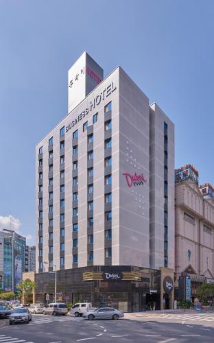 a large building with cars parked in a parking lot at Dubai Hotel in Gwangju