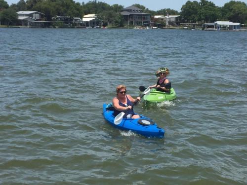 two people are riding on kayaks in the water at Valentine Lakeside in Kingsland