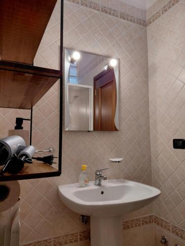 a bathroom with a sink and a mirror at La Terrazza Apartment in Cosenza