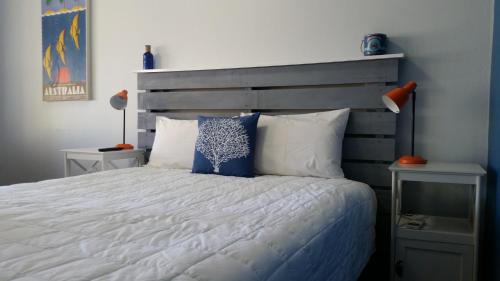 a bedroom with a large bed with blue and white pillows at Karuah Gardens Motel in Karuah
