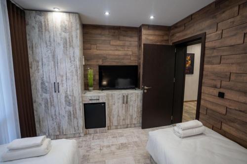 a bedroom with two beds and a flat screen tv at Къща за гости Бъчвата in Elkhovo
