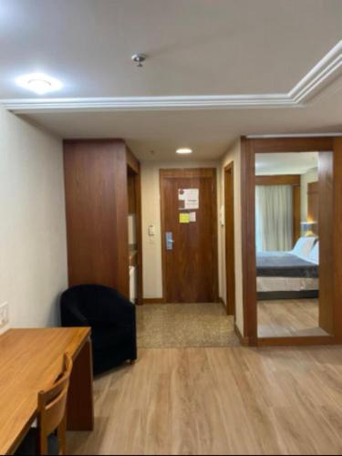 a room with a desk and a bedroom with a bed at Lindo flat Grand Mercoure triplo in Brasília