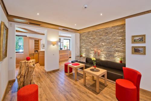a living room with red chairs and a brick wall at Hotel Bären in Rottweil