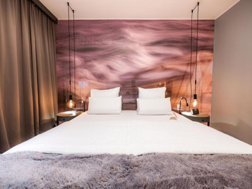 a bedroom with a bed with a painting on the wall at Hotel City Maribor in Maribor