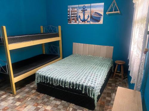 a bedroom with a bunk bed and blue walls at Casa com 2 Piscinas infantil e adulto a 450m da Praia Até 15 Pessoas in São Sebastião