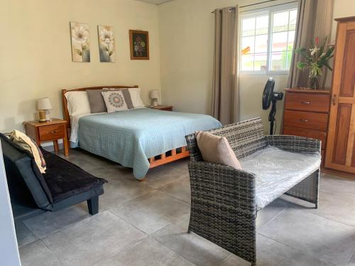 a bedroom with a bed and a couch and a chair at Venus Lodging House in Alto Boquete